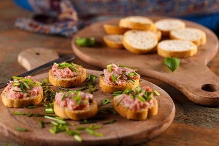 German teewurst on a slice of bruschetta with chopped fresh chivesの写真素材