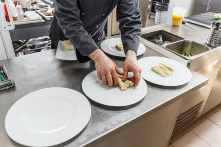 Male cooks preparing meals in restaurant kitchenの写真素材