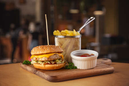 Delicious grilled chicken burger served with fries and hot tomato sauceの写真素材
