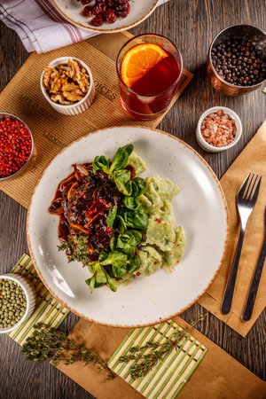 Flat lay of slow cooked beef cheeks with gnocchi and baby spinach saladの写真素材