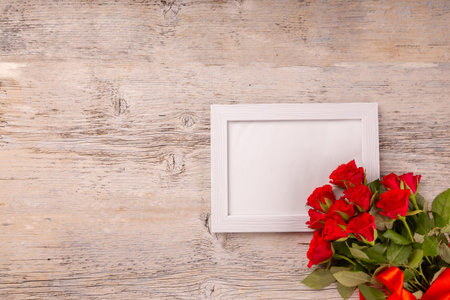 Bouquet of red roses decorated with space for your text on white wooden background