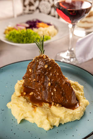 Roast pork with mashed potatoes and barbecue sauce at the restaurant tableの写真素材