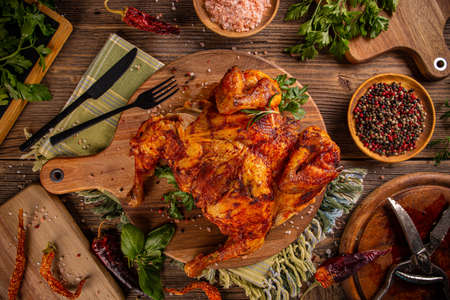Whole roasted chicken on wooden cutting board, flat lay, still lifeの写真素材