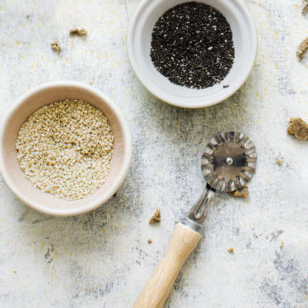 Cups of sesame by a roller knife cutter in a kitchen flatlayの素材