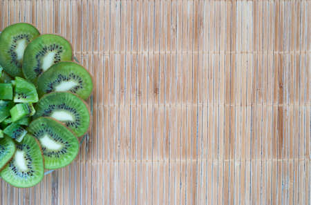 sliced kiwi on a bamboo backgroundの写真素材