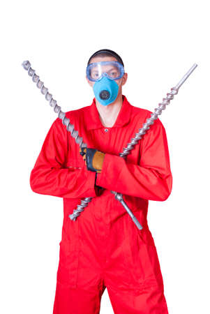 a young man in overalls holding a huge drillsの写真素材