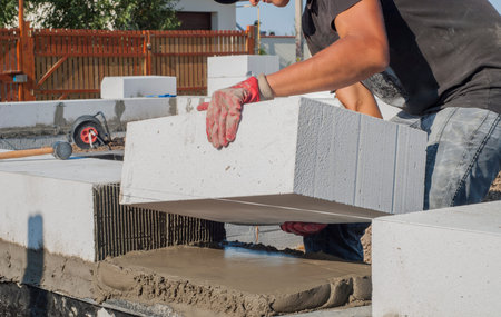 builder puts on grout aerated concrete block