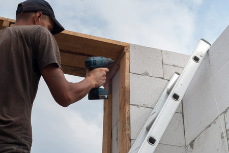 installer collects wooden structure using a cordless screwdriver