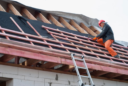 Worker installs bearing laths on the truss system