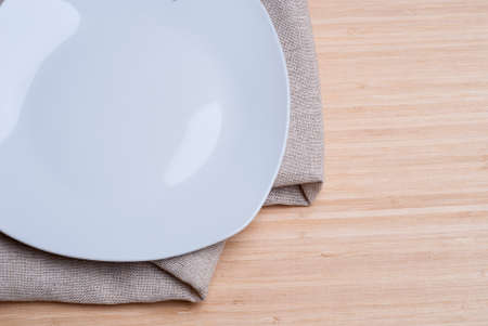 white plate and napkin on wooden background textureの写真素材