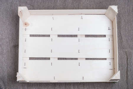 empty wooden box for fruits on a background of burlapの写真素材