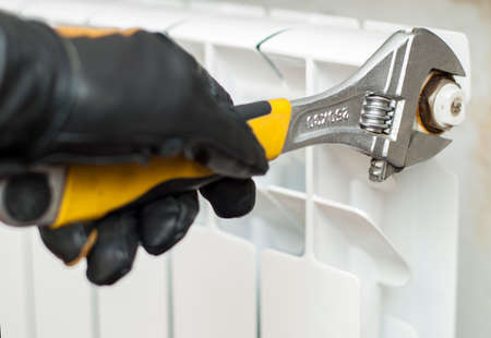 man holding wrenches and connects plumbing fittingsの写真素材