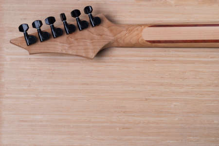 electric guitar fretboard on a wooden background textureの写真素材