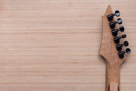 electric guitar fretboard on a wooden background textureの写真素材
