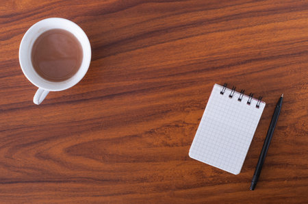 notebook and coffee on a wooden table