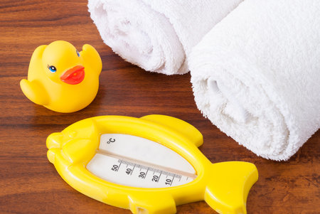 thermometer, rubber ducky and a children's bathrobe on the table