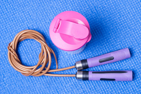 sports equipment and nutritious cocktail on a blue mat