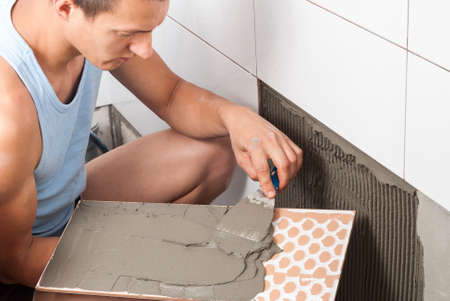 master applies the adhesive for ceramic tilesの写真素材