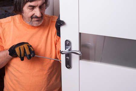 handyman repair the door lock in the roomの写真素材