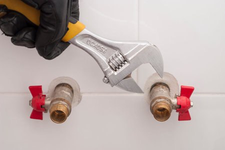 man holding wrenches and connects plumbing fittingsの写真素材