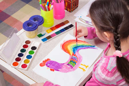 little girl paints on a piece of paperの写真素材