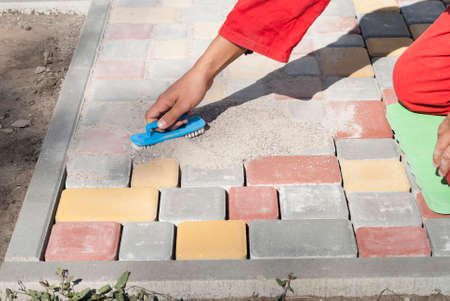 builder fills the seams between the paving slabsの写真素材