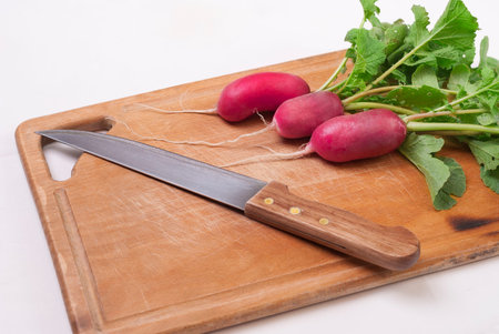 Fresh radish and knife on a culinary board