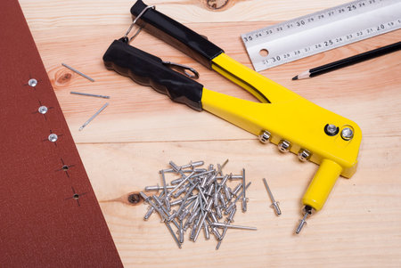 handgun and metal rivets on a wooden backgroundの写真素材