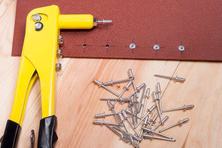 handgun and metal rivets on a wooden backgroundの写真素材