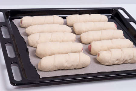 process of home-cooking sausages in a doughの写真素材