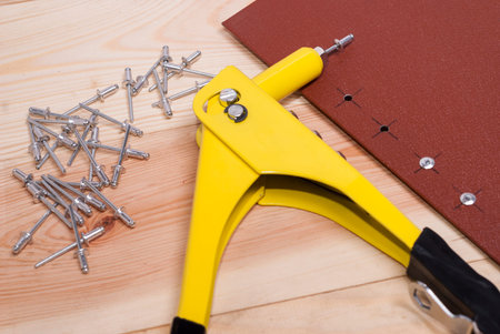 handgun and metal rivets on a wooden background