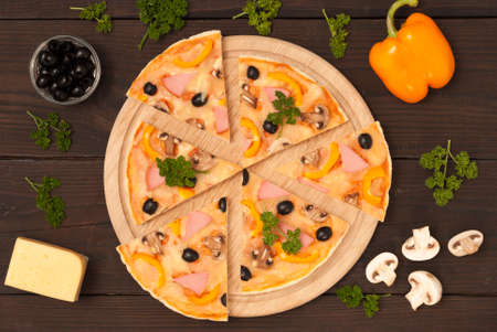 italian pizza and ingredients on a wooden backgroundの写真素材