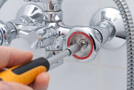 plumber repairs the faucet in the bathroomの写真素材