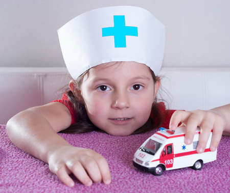 little girl doctor playing with ambulance carの写真素材
