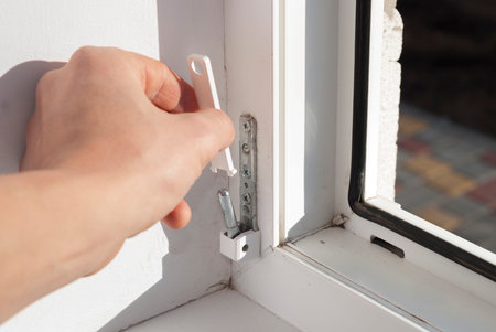 handyman repairs the lower loop of the plastic window