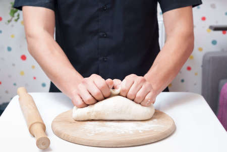 chef man kneads pizza dough on the tableの写真素材