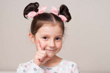 Portrait of a charming little girl in a pensive postureの写真素材