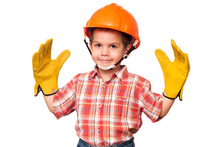 little boy handyman in red helmet and with big work glovesの写真素材