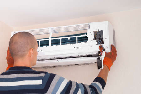 specialist cleans and repairs the wall air conditionerの写真素材