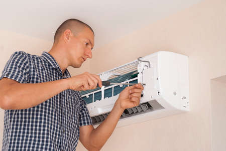 worker installs the indoor unit air conditioner on the wallの写真素材