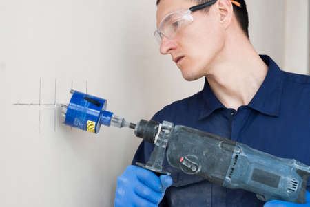 an electrician uses a diamond bit for drilling reinforced concreteの写真素材
