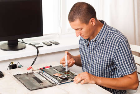 repairman applies thermal paste to laptop processorの写真素材