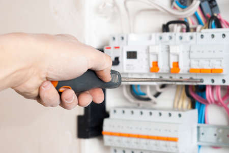 electrician connects wire to automatic fuse deviceの写真素材