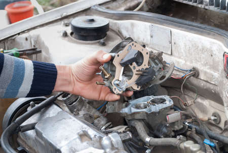 the repairman replaced the gasket in the carburetor and installs it in placeの写真素材