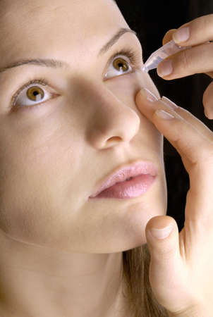woman using eyedropsの写真素材