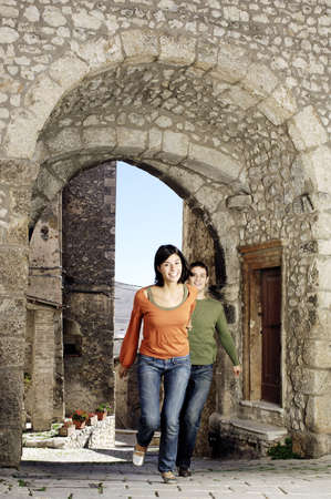 young couple running in a villageの写真素材