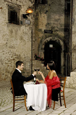young couple toasting at restaurantの写真素材