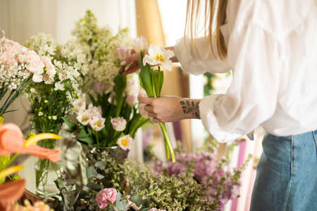 Florist at work: woman making fashion modern bouquet of different flowersの写真素材