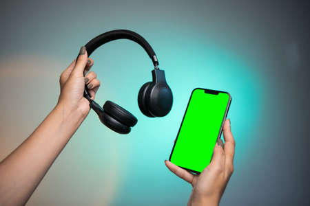 Modern headphone and gadget with green screen. Black headphonesの写真素材