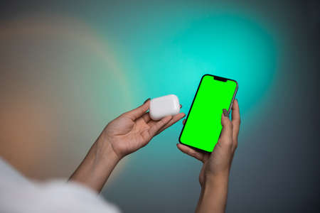 Modern wireless headphone and gadget with green screen.の写真素材